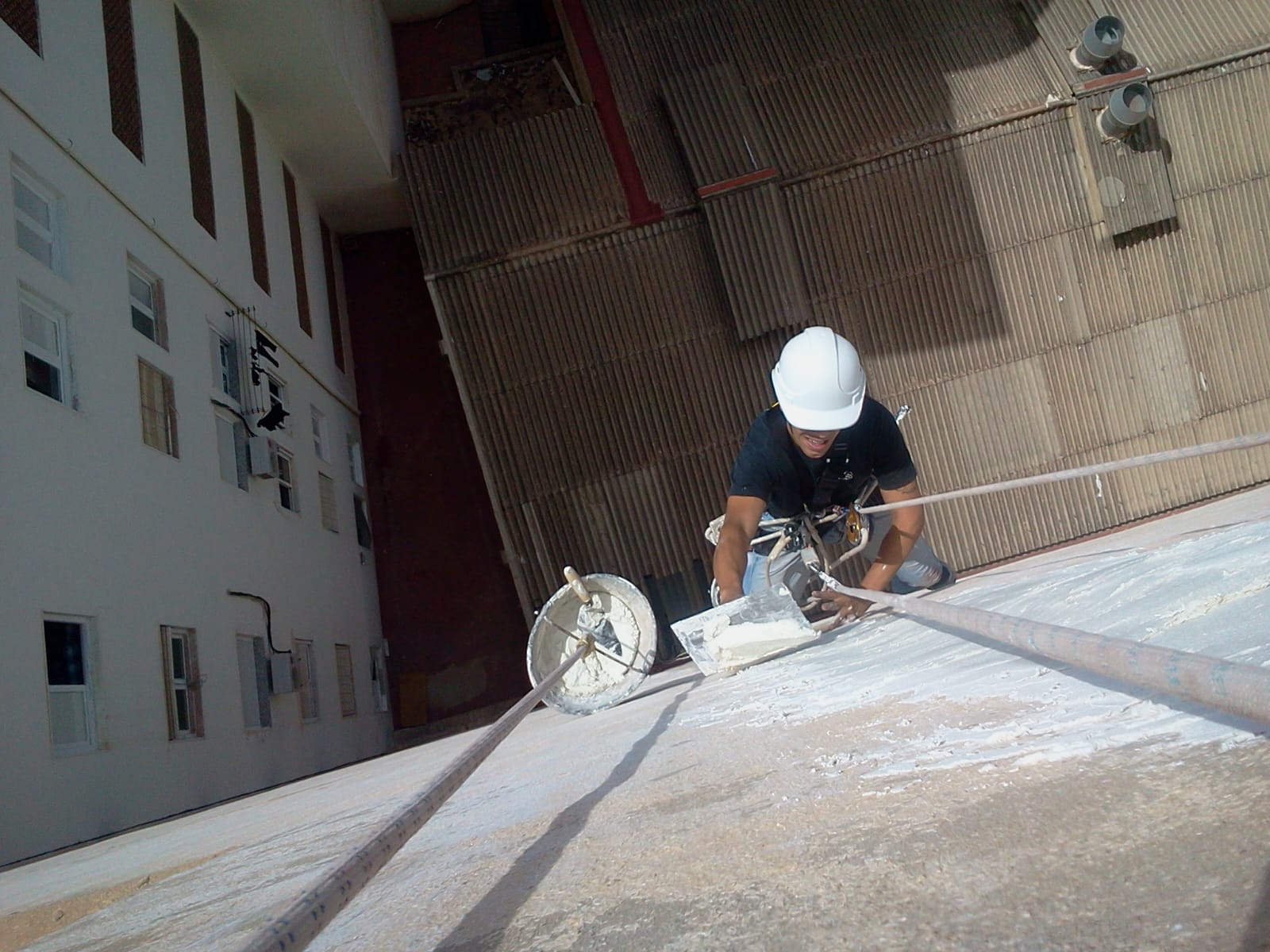 Técnico descendiendo fachada de edificio en Elche