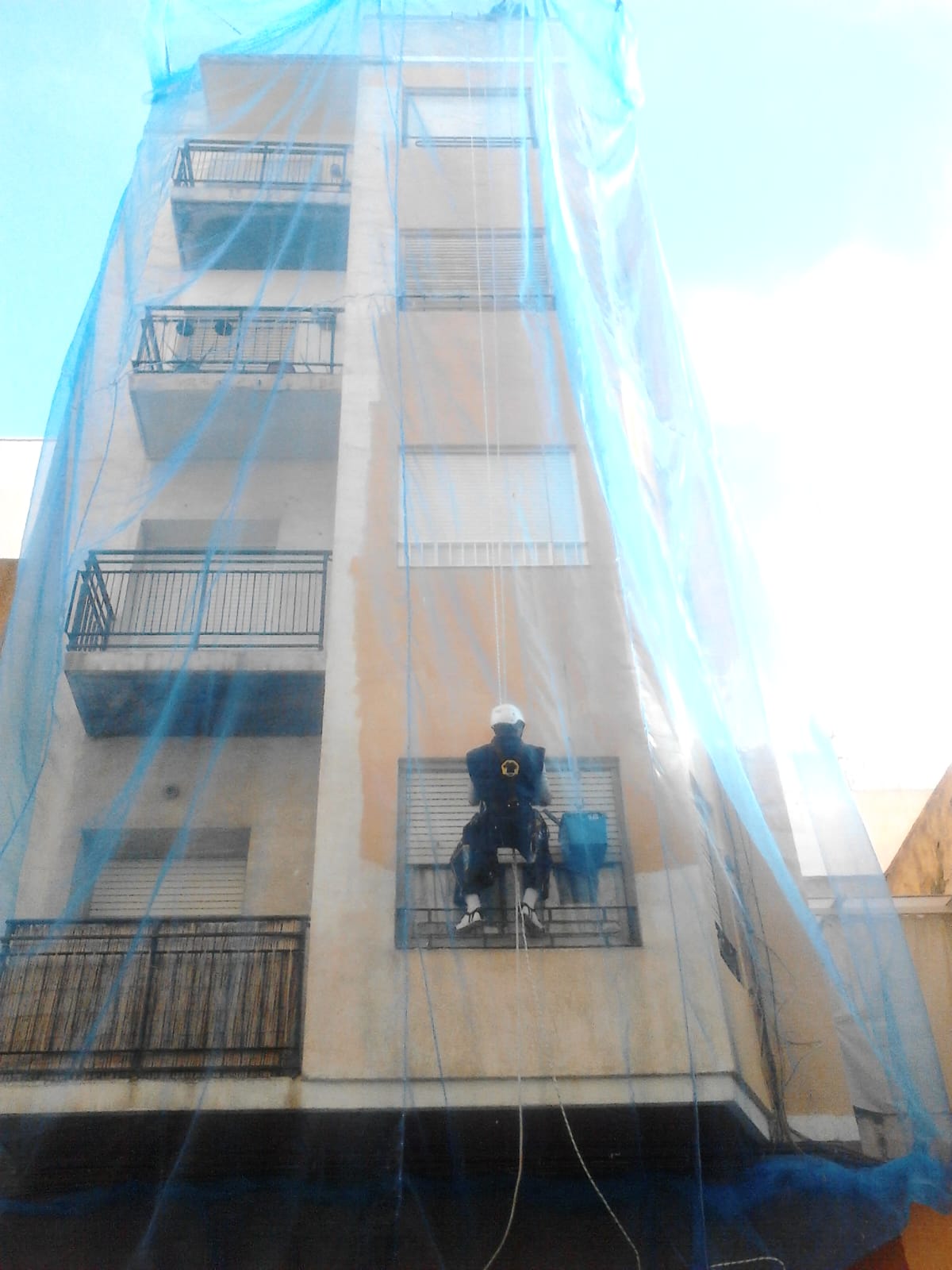 Técnico impermeabilizando cubierta plana con EPIs